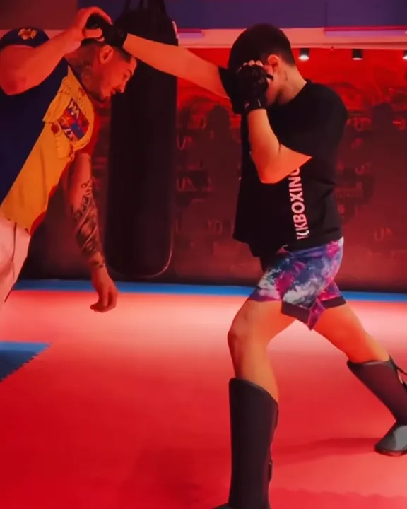 Sportiv lucrând la palme cu antrenorul, în sală.